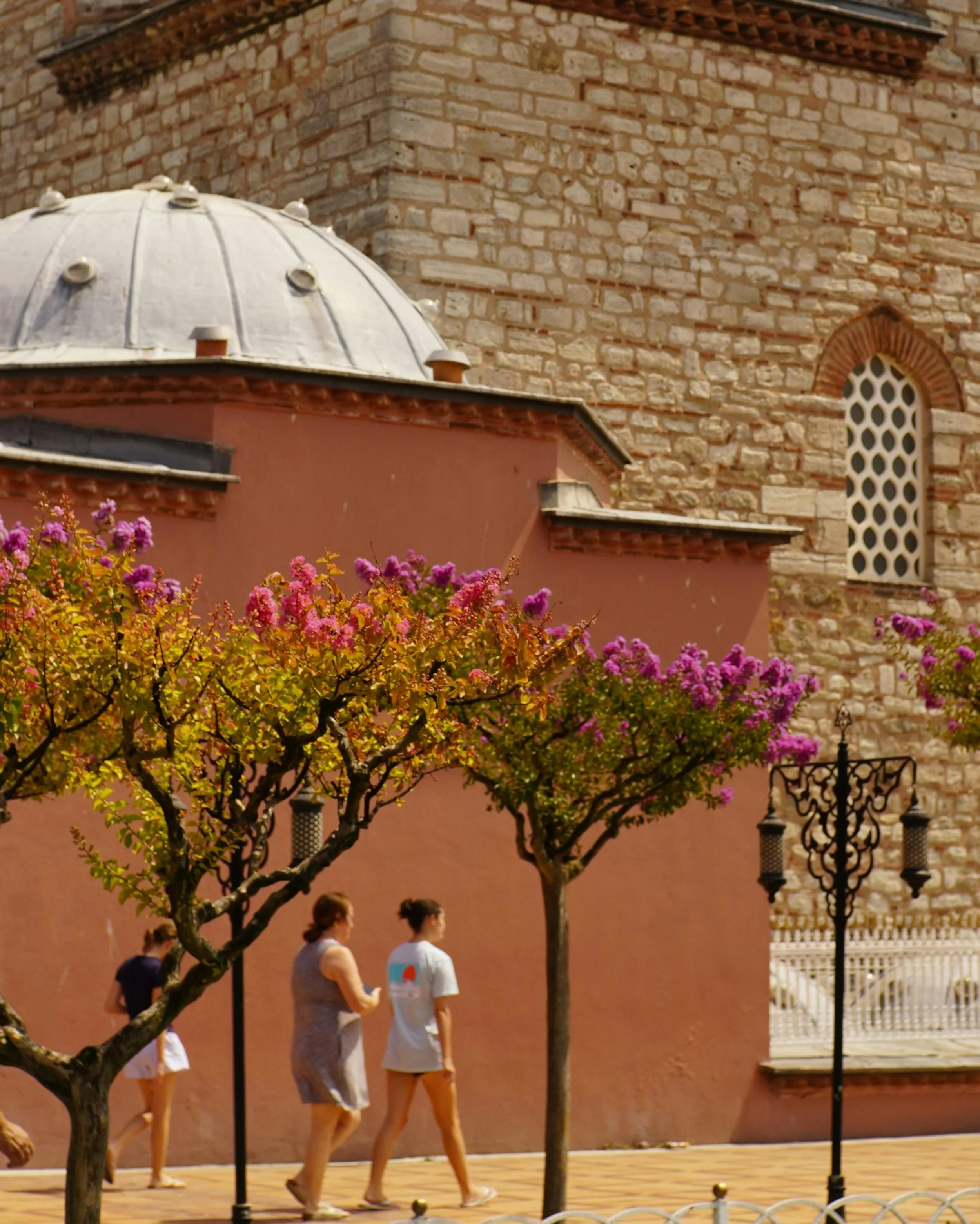An active midlife woman happily sightseeing on foot through a new city, staying energized and hitting her daily step goal as part of a healthy travel routine.