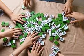 Close-up of Mahjong tiles being shuffled during the ‘wash,’ highlighting tactile play and mindful, screen-free brain activity