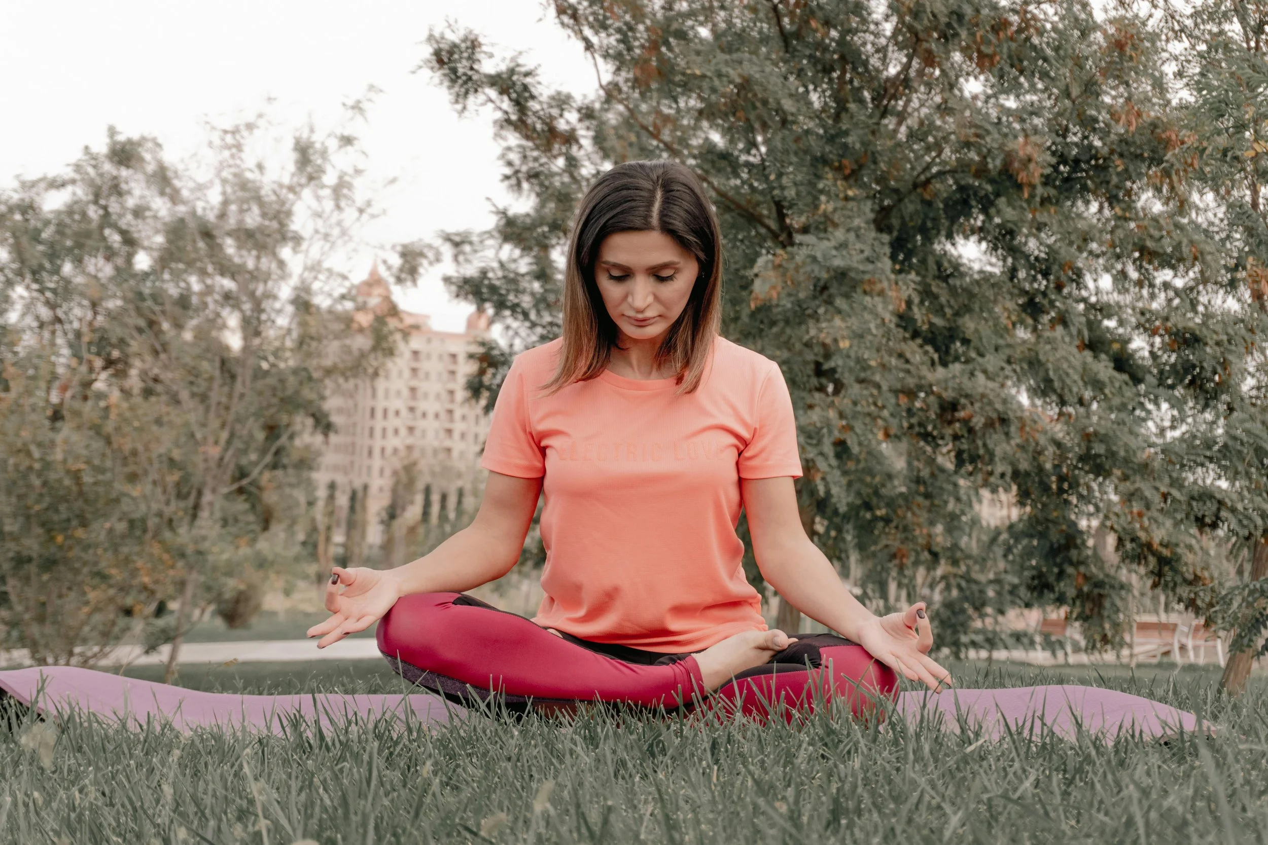 A woman in midlife practicing mindful meditation outdoors to support emotional health and immune resilience.