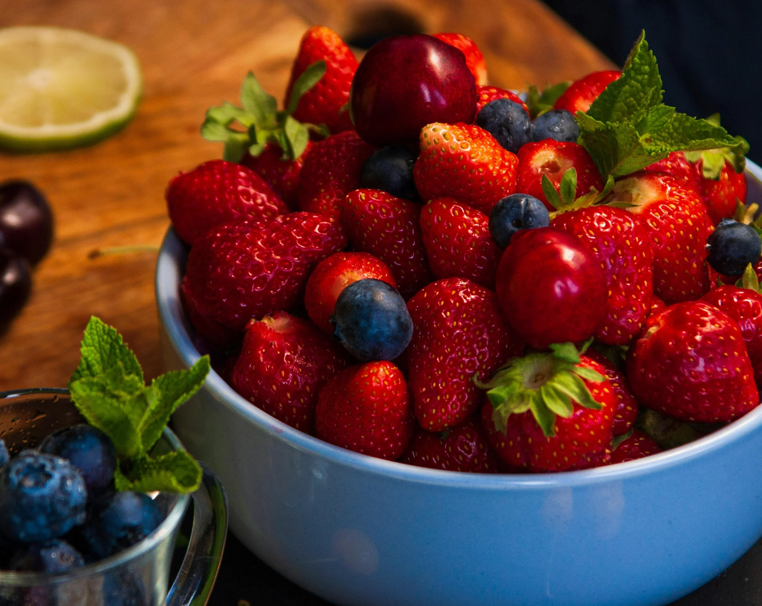 A vibrant bowl of fresh berries on a rustic outdoor table, symbolizing natural nourishment and body positivity in midlife.
