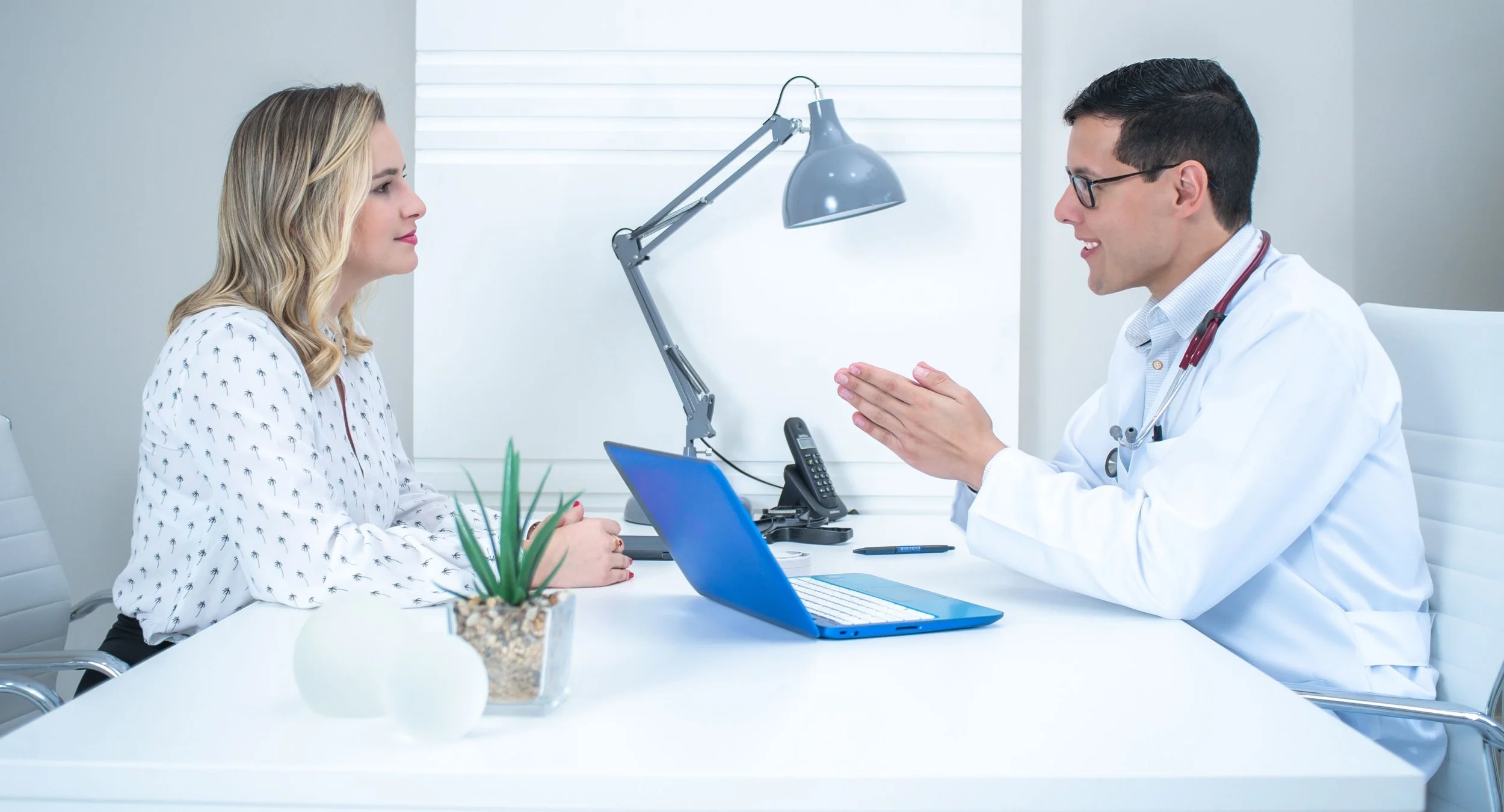 A doctor and a female patient sitting in an office reviewing comprehensive lab results together.