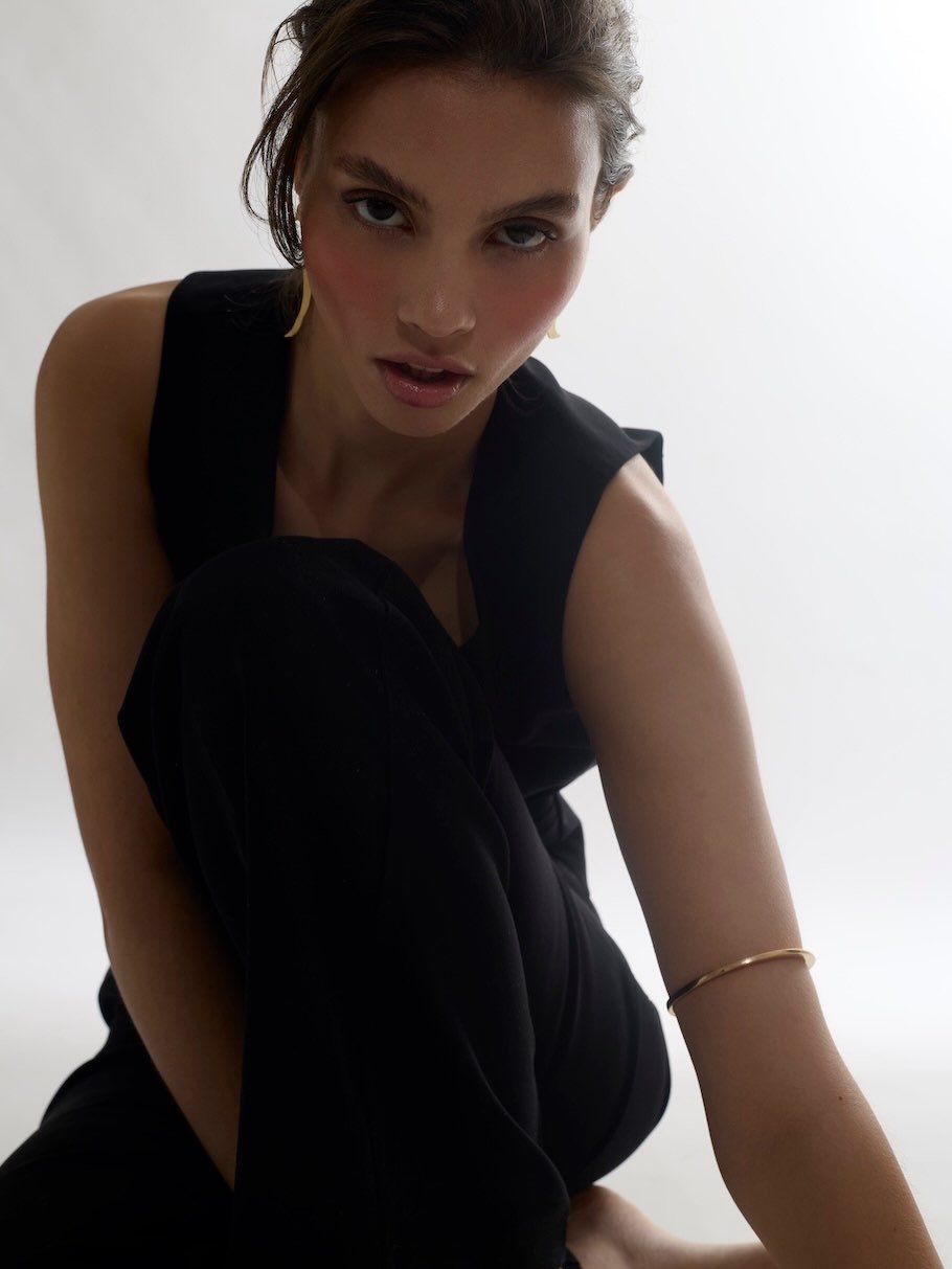 For this editorial, the visual language was built around restraint: a black silhouette, soft light, bare skin, sculptural jewellery and a pose that keeps the focus on presence rather than excess.
In styling and art direction, the most important decis