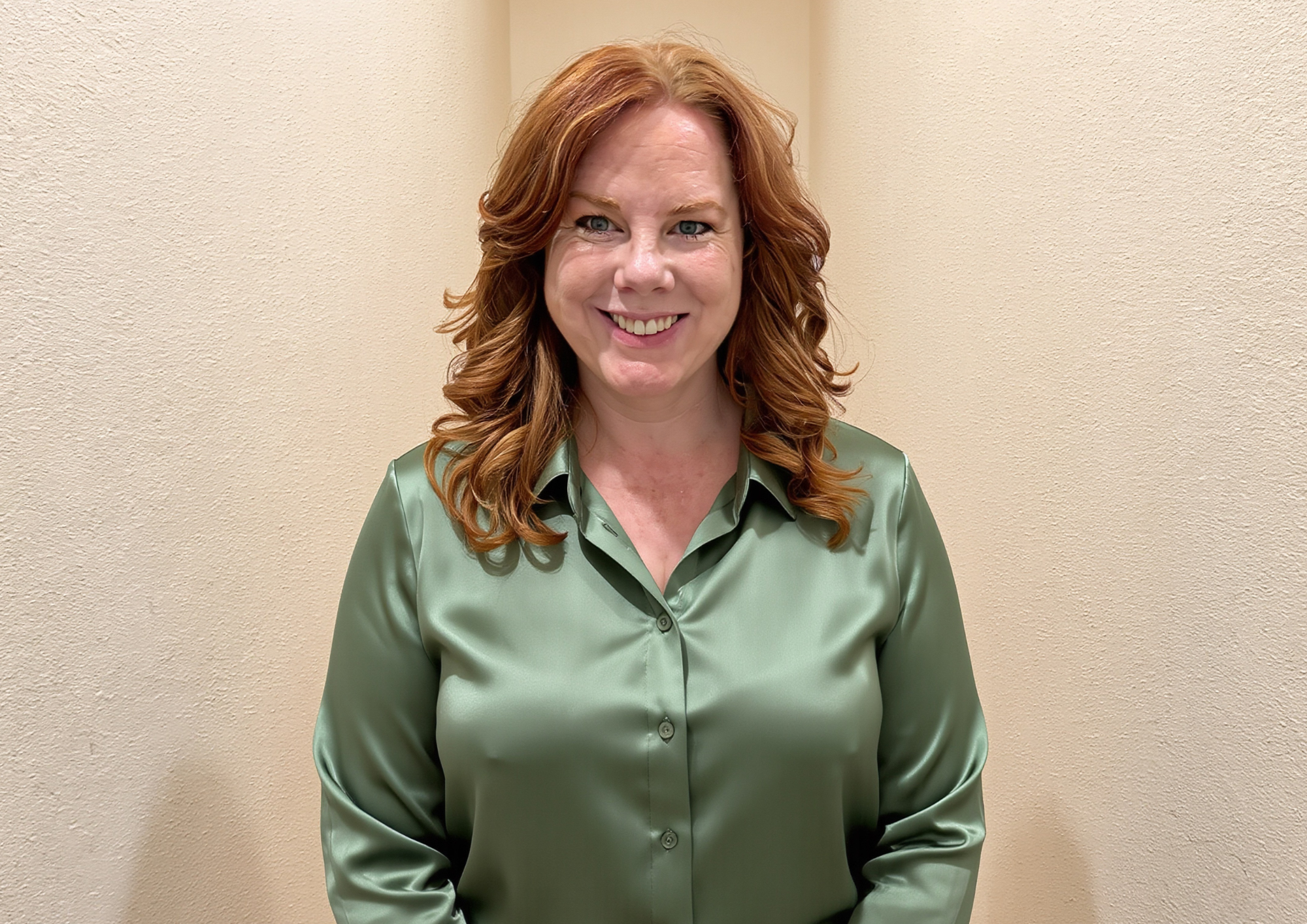 Amanda green blouse cream wall headshot .png