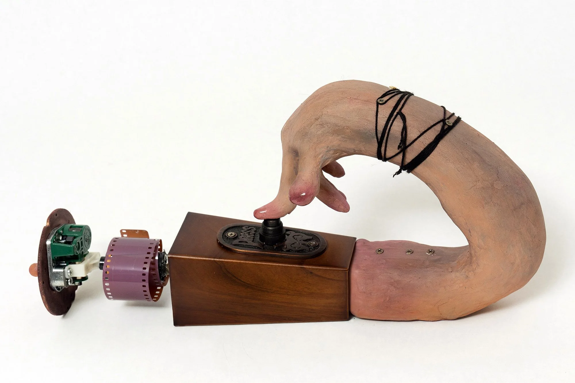 Press It, wooden sofa leg, bronze doorbell and button, music box, 35mm film, thread, wood screw, stone clay, acrylic, pigment, epoxy, 13x8x3 inches, 2023.jpg