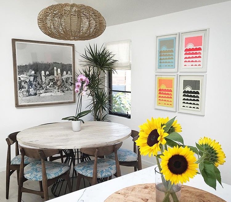 Large black and white photograph by Mary Ellen Matthews of Ditch Plains Montauk displayed in Dre Shapiro's home alongside colorful art prints