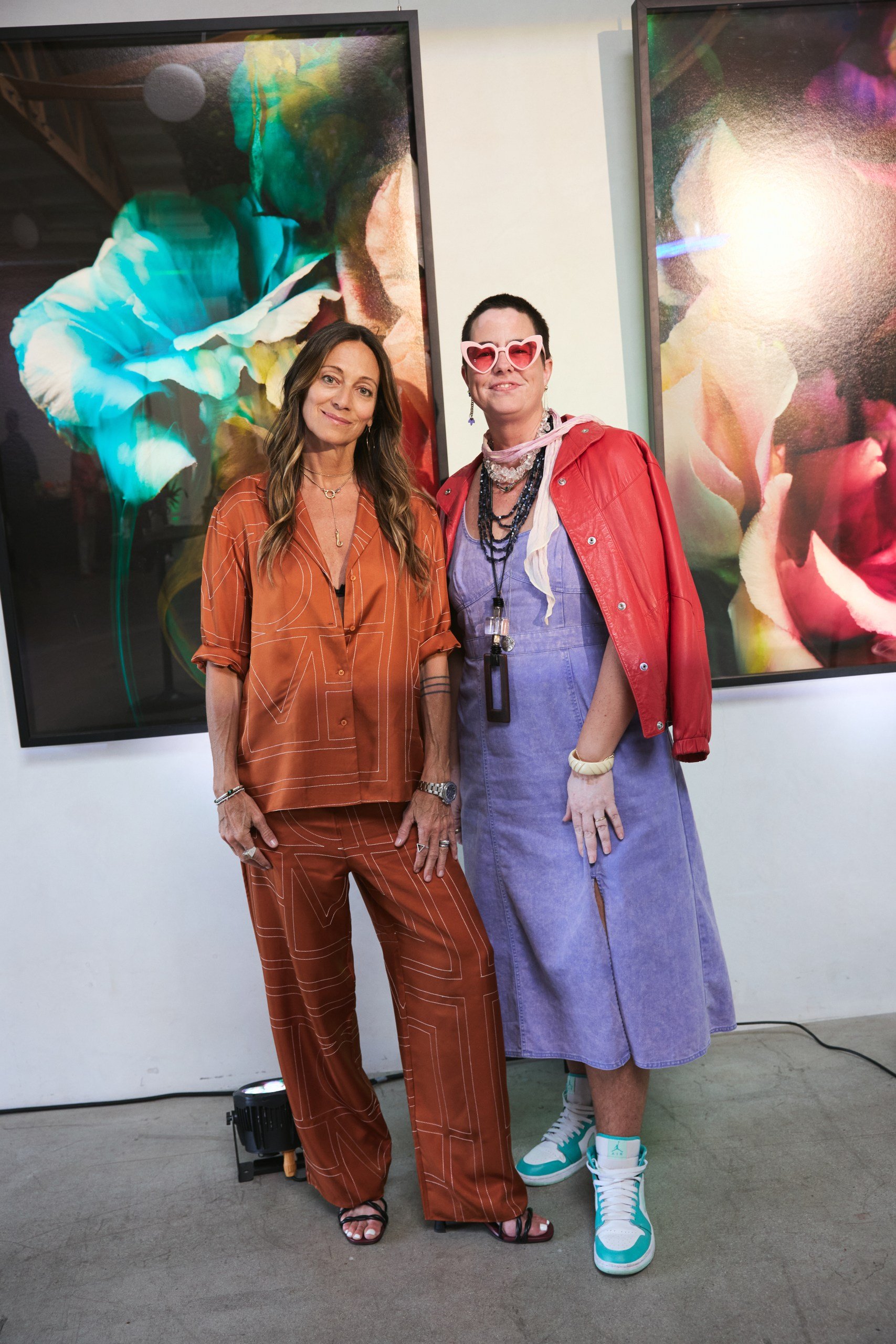 Dre Shapiro and Yael Wulfhart of Wolf Art Gallery standing in front of photography by Javiera Estrada at Lacunafest