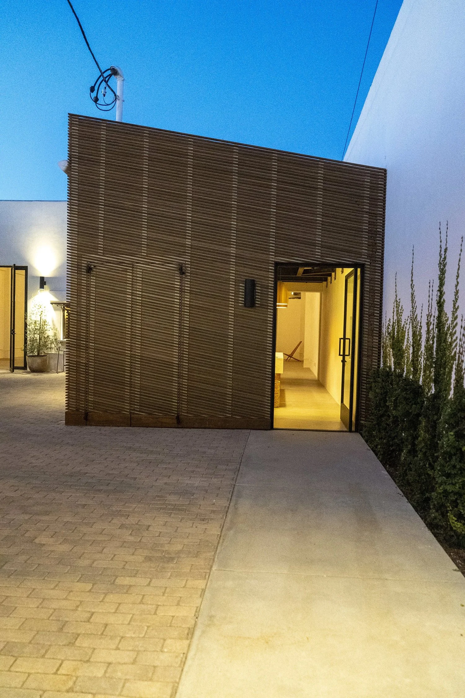 Lacuna exterior courtyard and restroom building at night designed by Lara Hoad Architecture Design Los Angeles