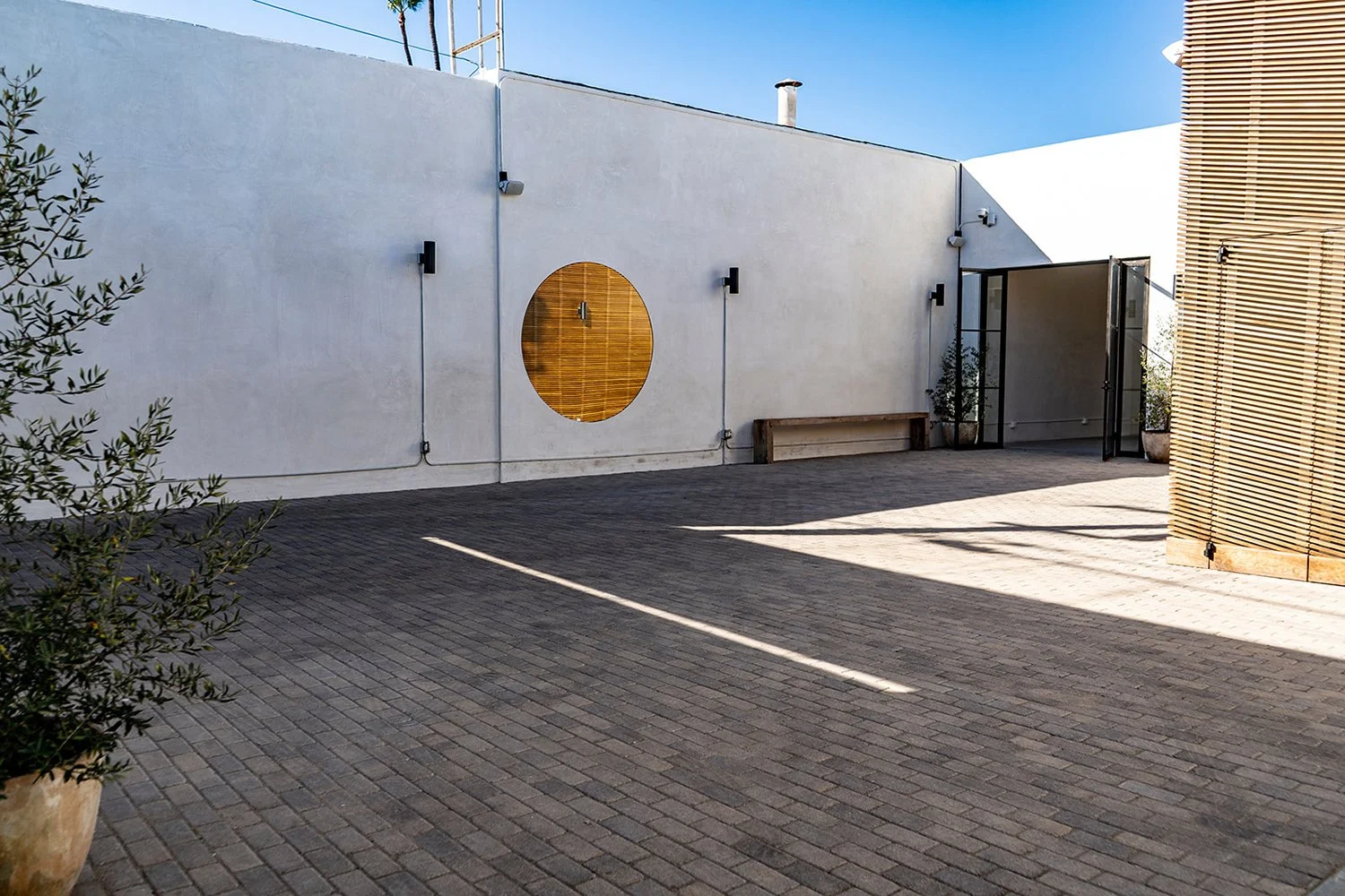 Lacuna exterior white wall with circle detail and courtyard West Adams Los Angeles