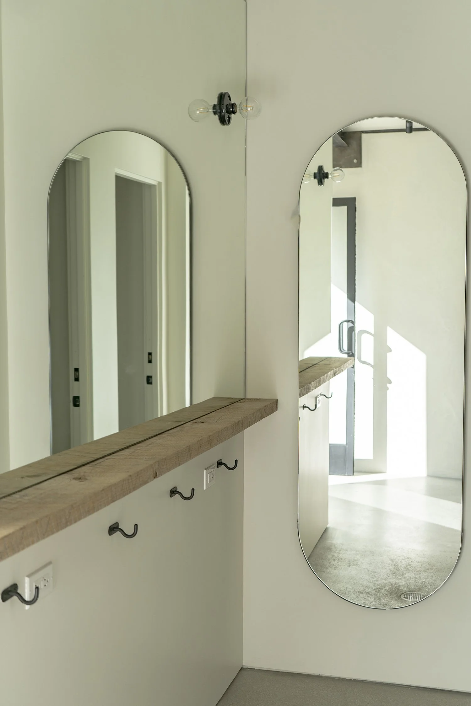 Lacuna bathroom with arched mirror and vanity West Adams