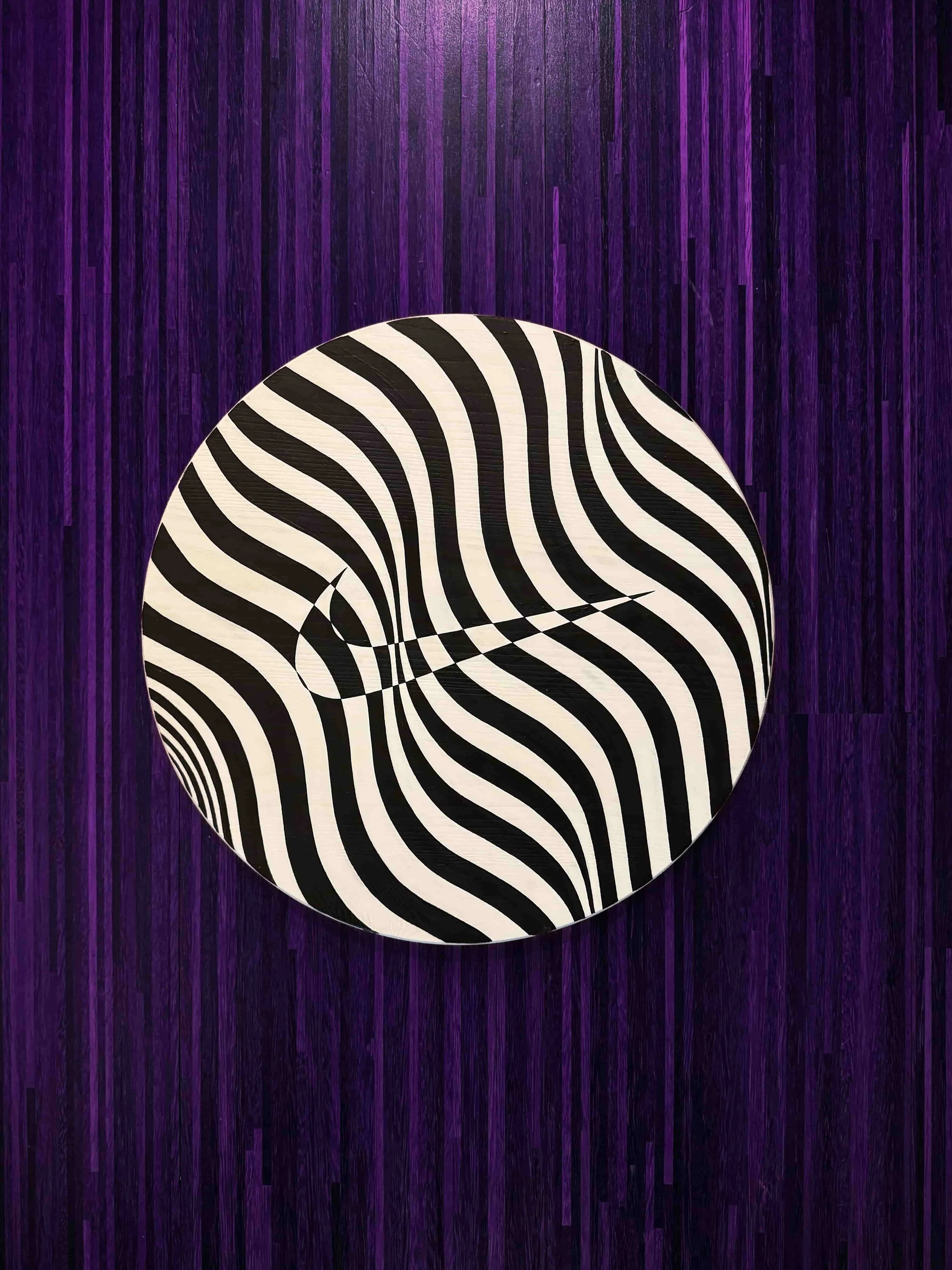  Circular black and white op art painting with hypnotic wavy stripe pattern creating optical illusion movement and bold contrast 