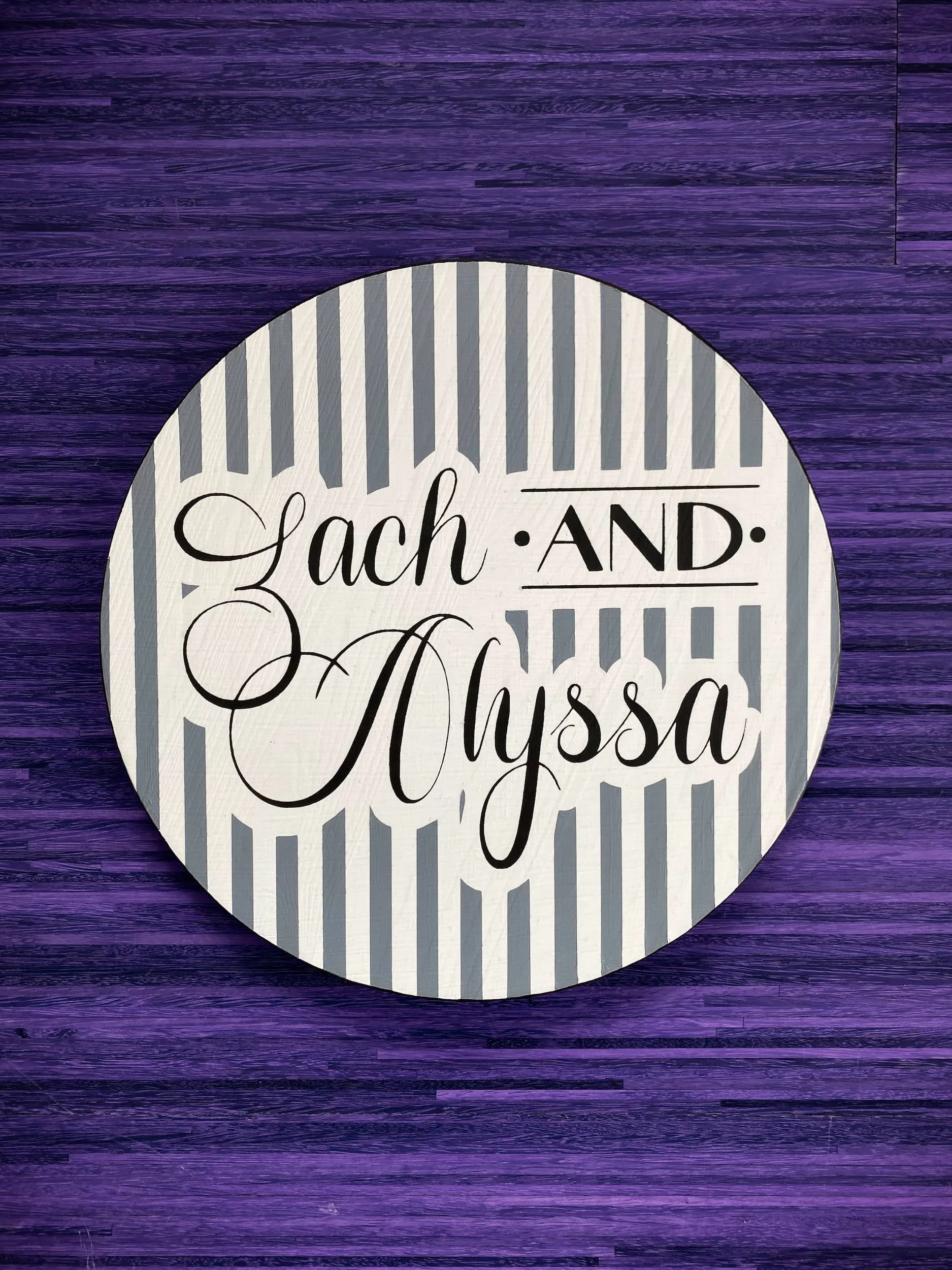 Custom circular wedding sign featuring elegant black calligraphy over striped geometric background with modern event decor styling