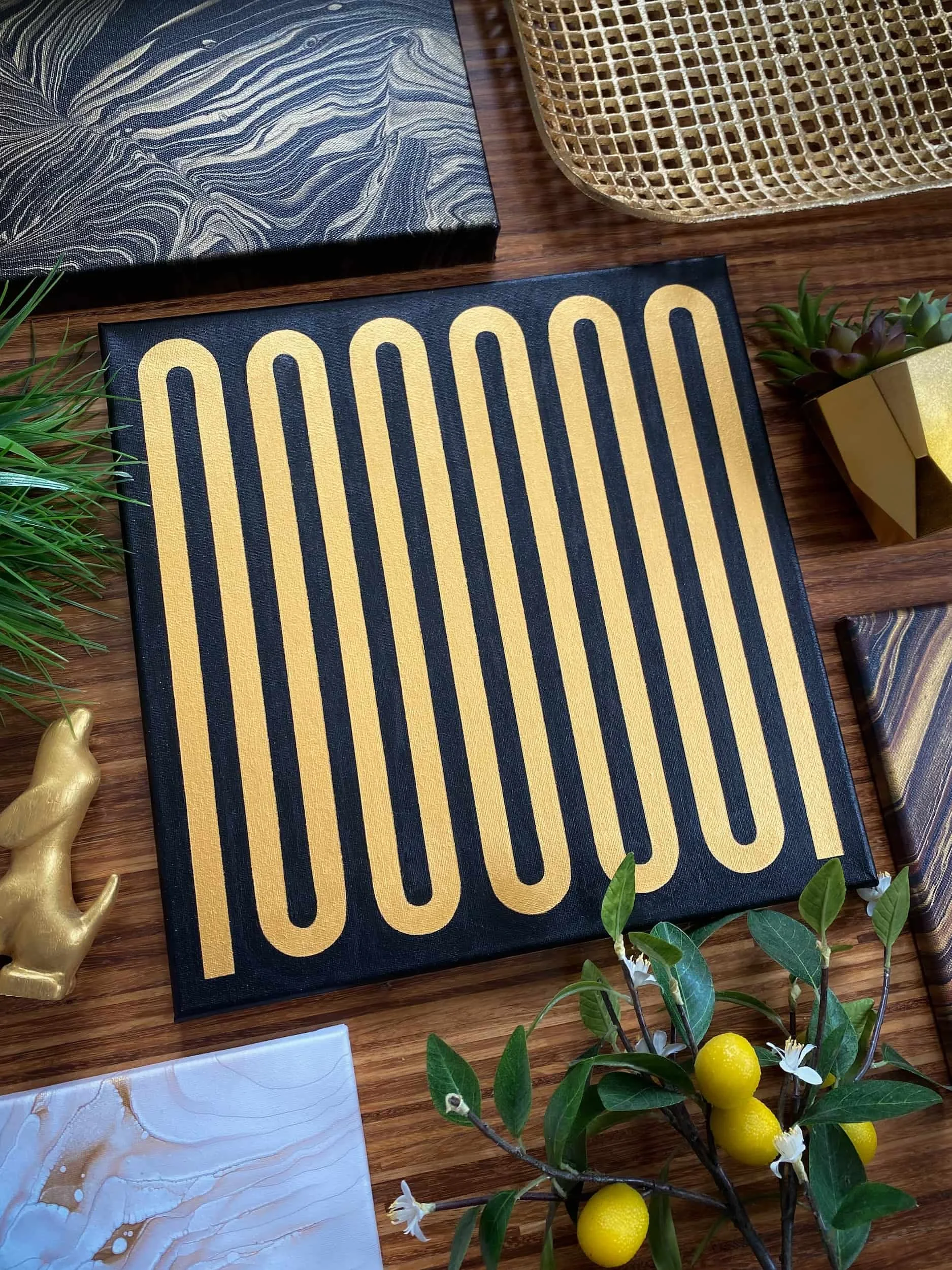 Minimalist acrylic painting featuring looping gold linework on a dark background with modern geometric rhythm and retro-inspired design