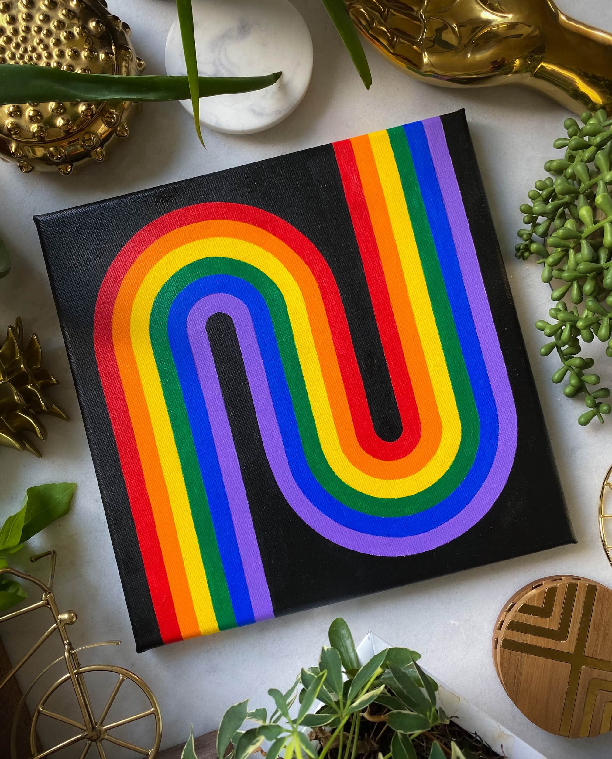 Minimalist rainbow acrylic painting with looping curved stripes, bold black background, and clean modern geometric design