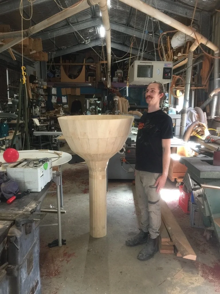 Max Baker-Finch beside a large coopered sculptural form under construction in Ross Annels' studio at the Cooroora Institute, Black Mountain.