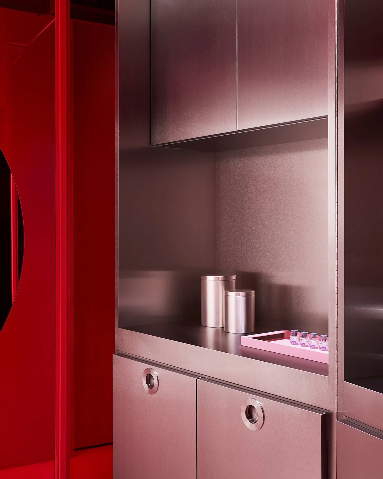 Close-up of custom brushed stainless steel cabinetry at Pout X, demonstrating how bespoke millwork seamlessly integrates and elevates essential clinical storage in a luxury medical spa.