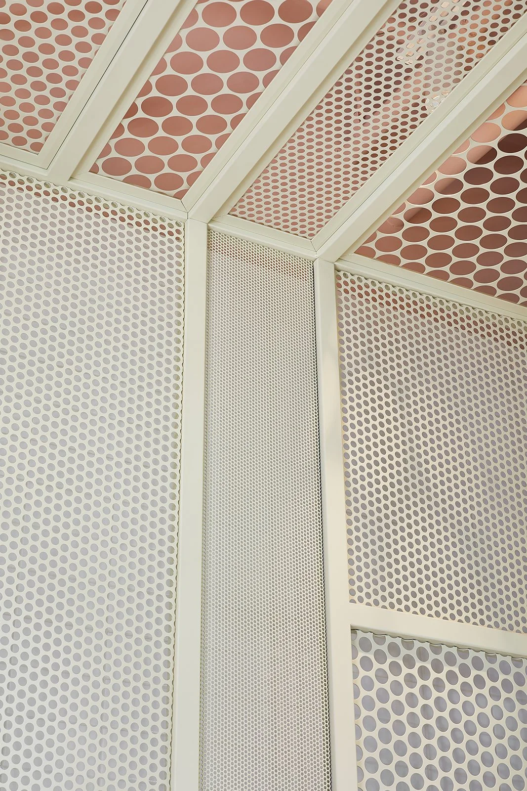 Ceiling with geometric panels featuring various sized dots in shades of cream, pink, and brown.