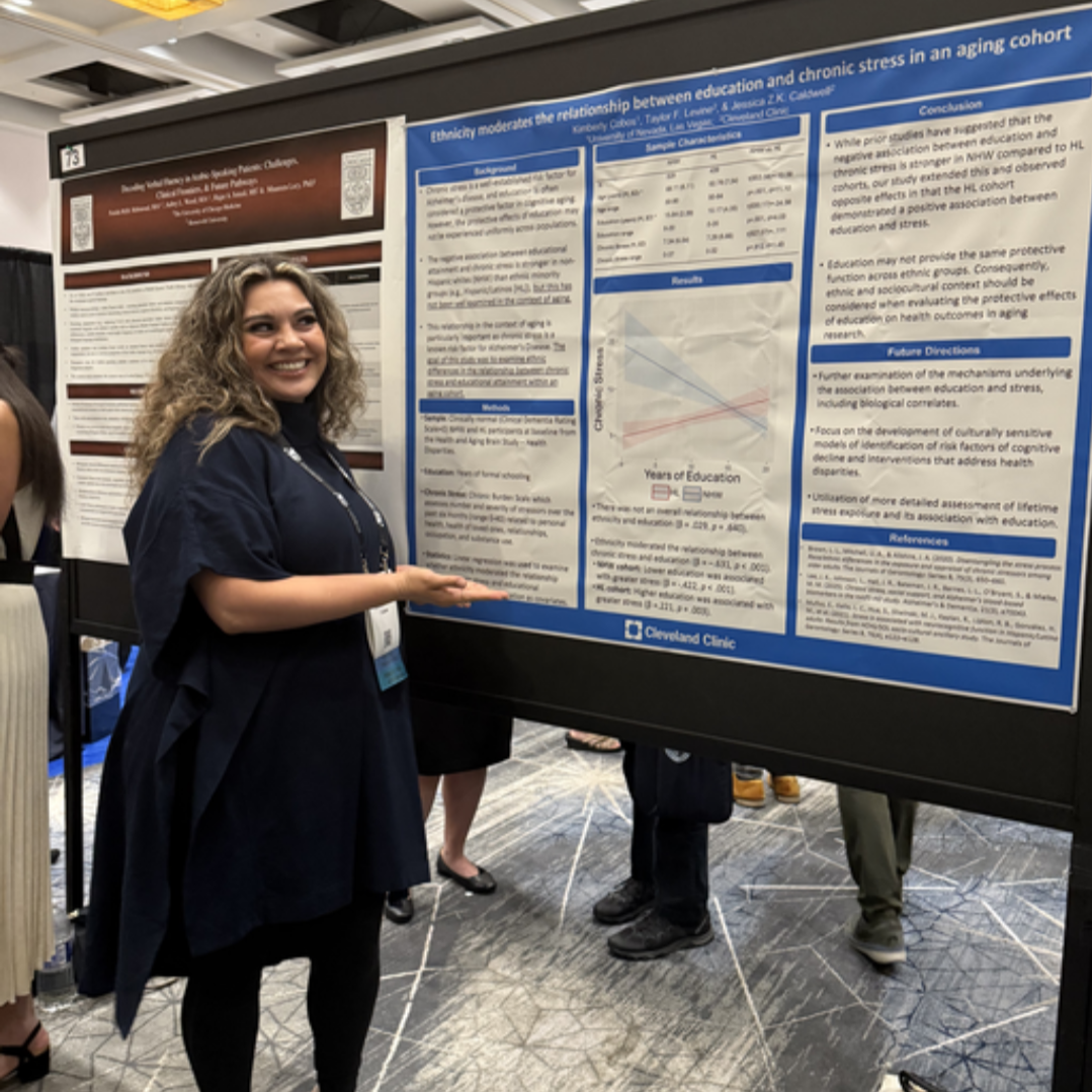 Staff, Kim Cobos, standing in front of their research poster