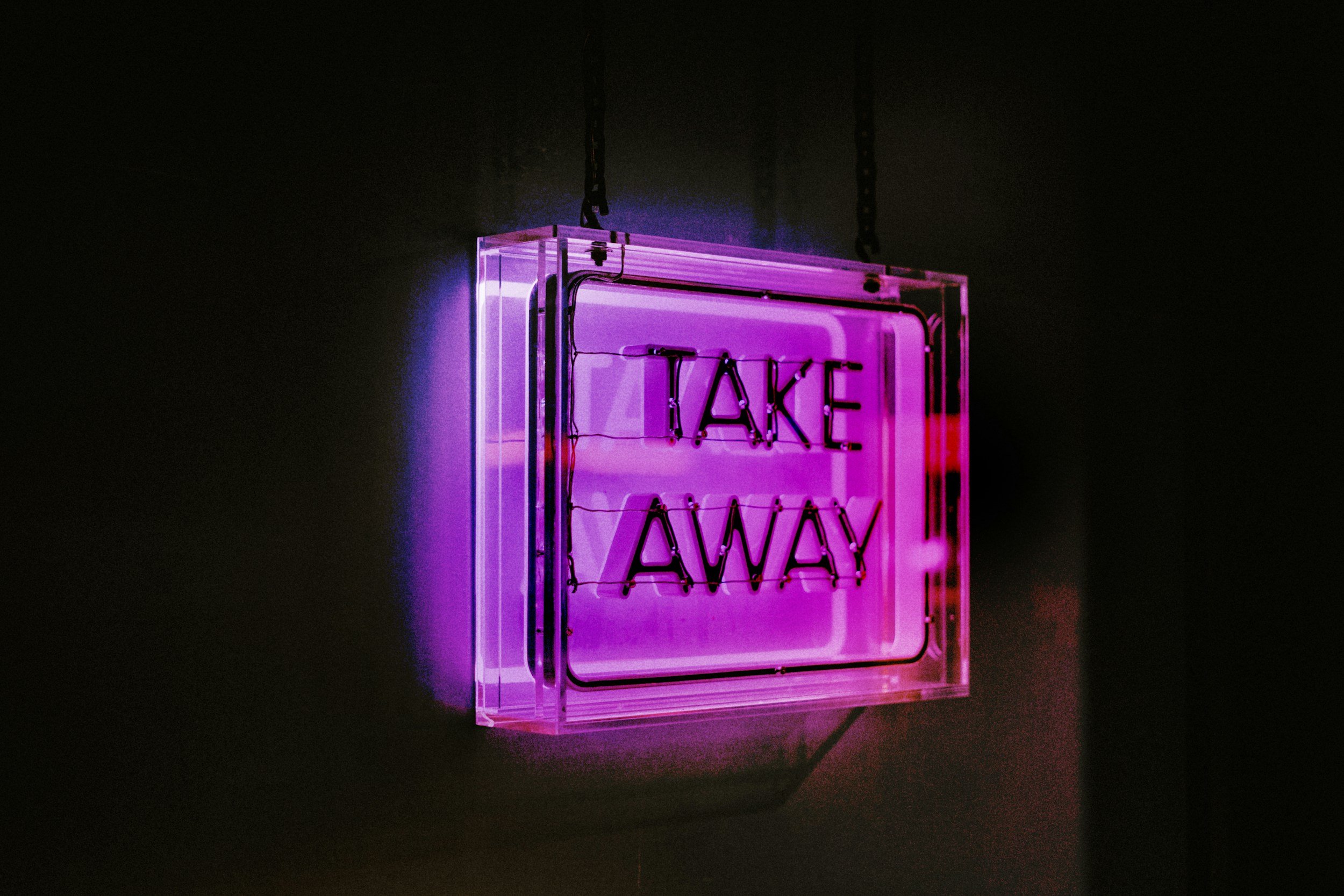 A neon sign reads, "Take Away"