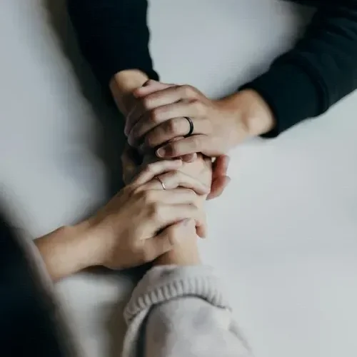 couple holding hands across white table
