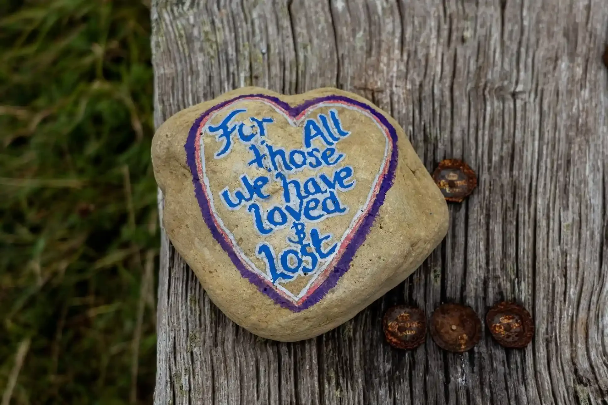 rock with a heart drawn on it that says For All those we have loved and lost