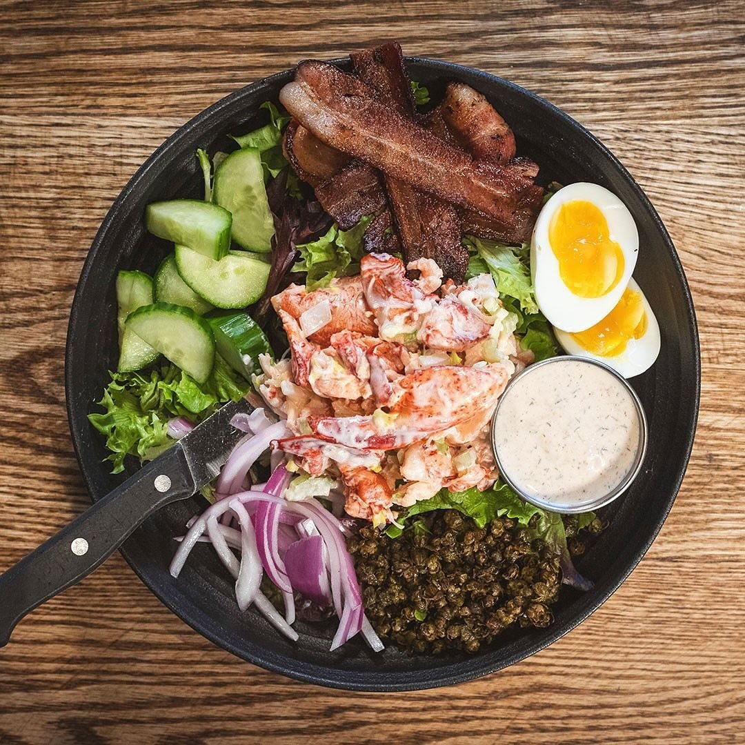 Bring in the dancing lobsters 🦞🦞🦞 The Cape Codder Bowl is now available at all locations, all summer long!⁠
⁠
Lobster salad, slab bacon, soft boiled egg, tomato, onion, cucumber, fried capers, chipotle dill ranch
