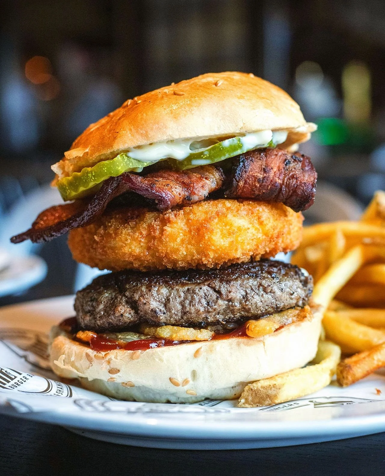 The 'Return of the Mac' is stacked with a 7oz. house grind burger, slab bacon, a crispy mac &amp; cheese croquette, whiskey BBQ sauce, frizzled onions, crinkle-cut pickles, and garlic mayo on a seeded roll.⁠
⁠
Big, messy, and exactly the kind of burg