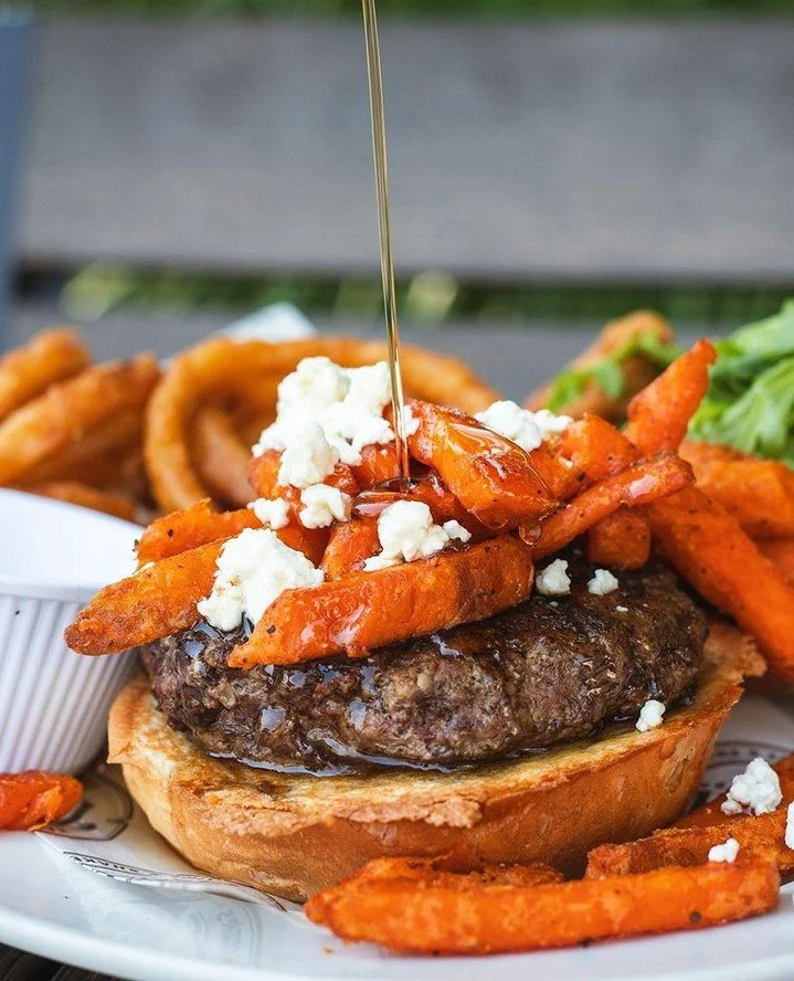 Sweet. Savory. Slightly unhinged. 🍔🍁⁠
⁠
Meet The Cinna "Bomb." A Brandt all-natural burger topped with cinnamon aioli, brown sugar bacon, arugula, sweet potato fries and creamy goat cheese on a buttery brioche roll, served with maple syru