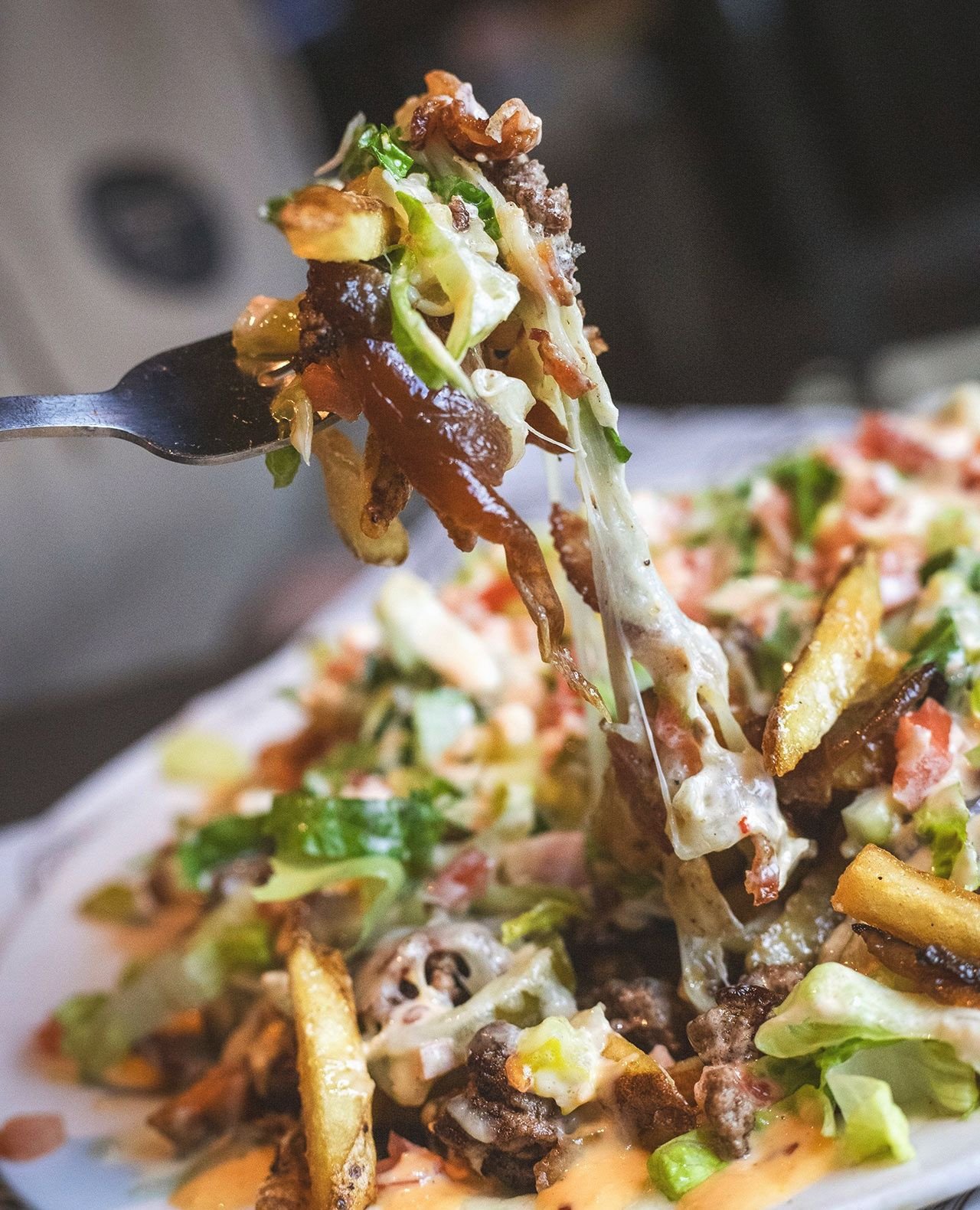 Our Top 10 Poutine piles crispy fries high with wagyu ground beef, bacon, cheddar, caramelized onion, pickled jalape&ntilde;o, tomato, pickles, lettuce and smash sauce.⁠
⁠
Part of our limited-time Grill &amp; Chill menu celebrating a decade of The Fi