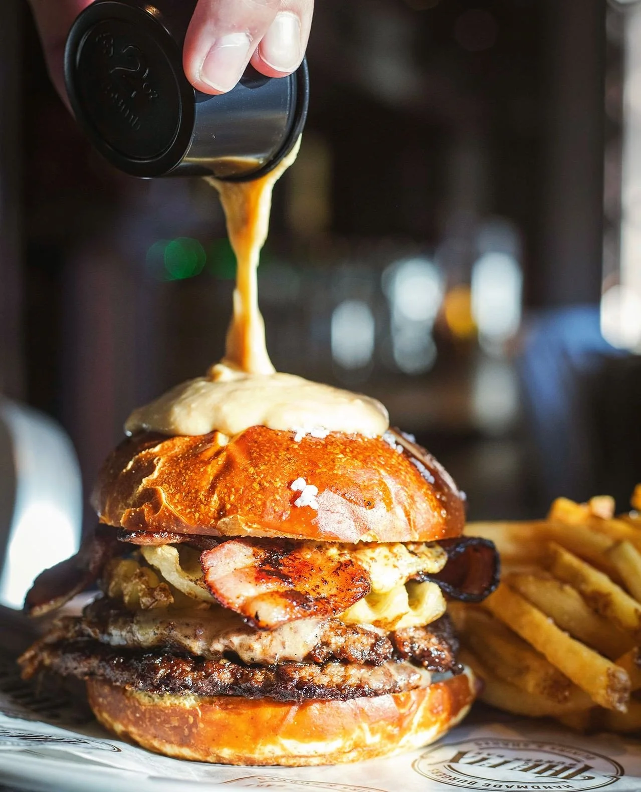 Who's got two thumbs and getting "Smashed Again" this weekend in Worcester 👍️👍️ This guy!⁠
⁠
2 smashed 4oz. patties, havarti cheese, waffle fries, slab bacon, spicy mustard, salted pretzel bun, side of beer cheese