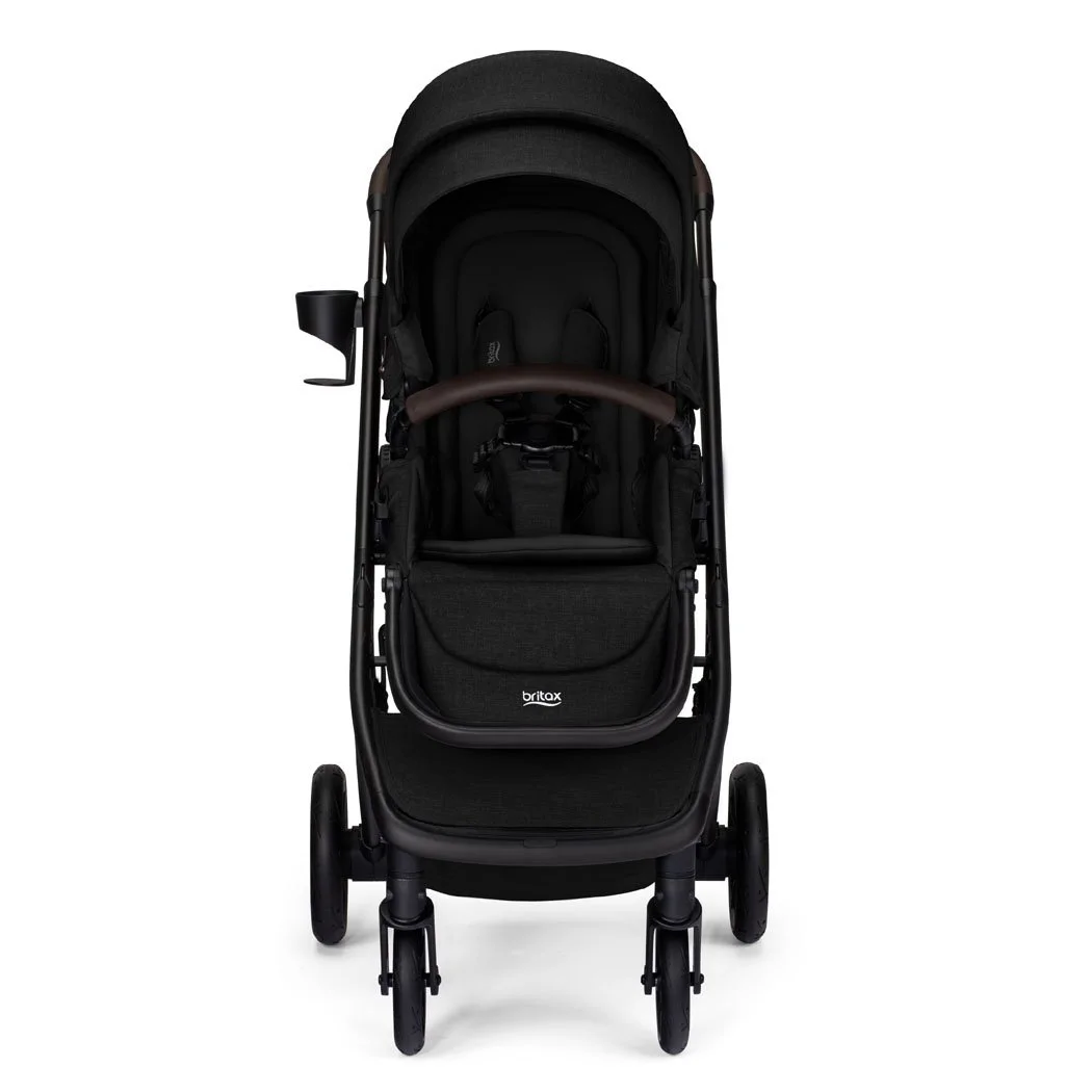 Poussette noire avec auvent, barre avant brune, porte-gobelet et logo Britax sur le repose-jambes. 