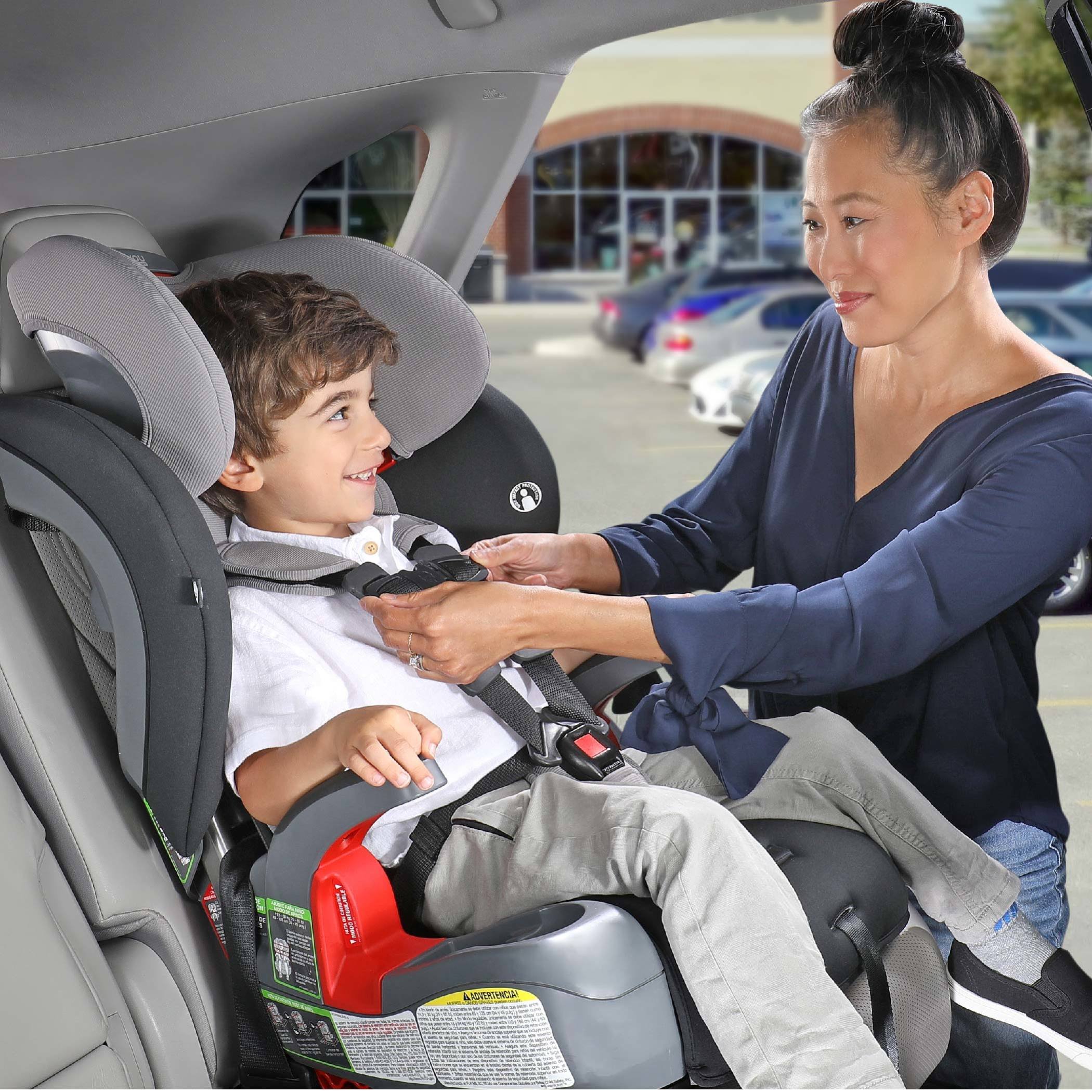 Mother adjusting the Harness on her childs harness-2-booster car seat