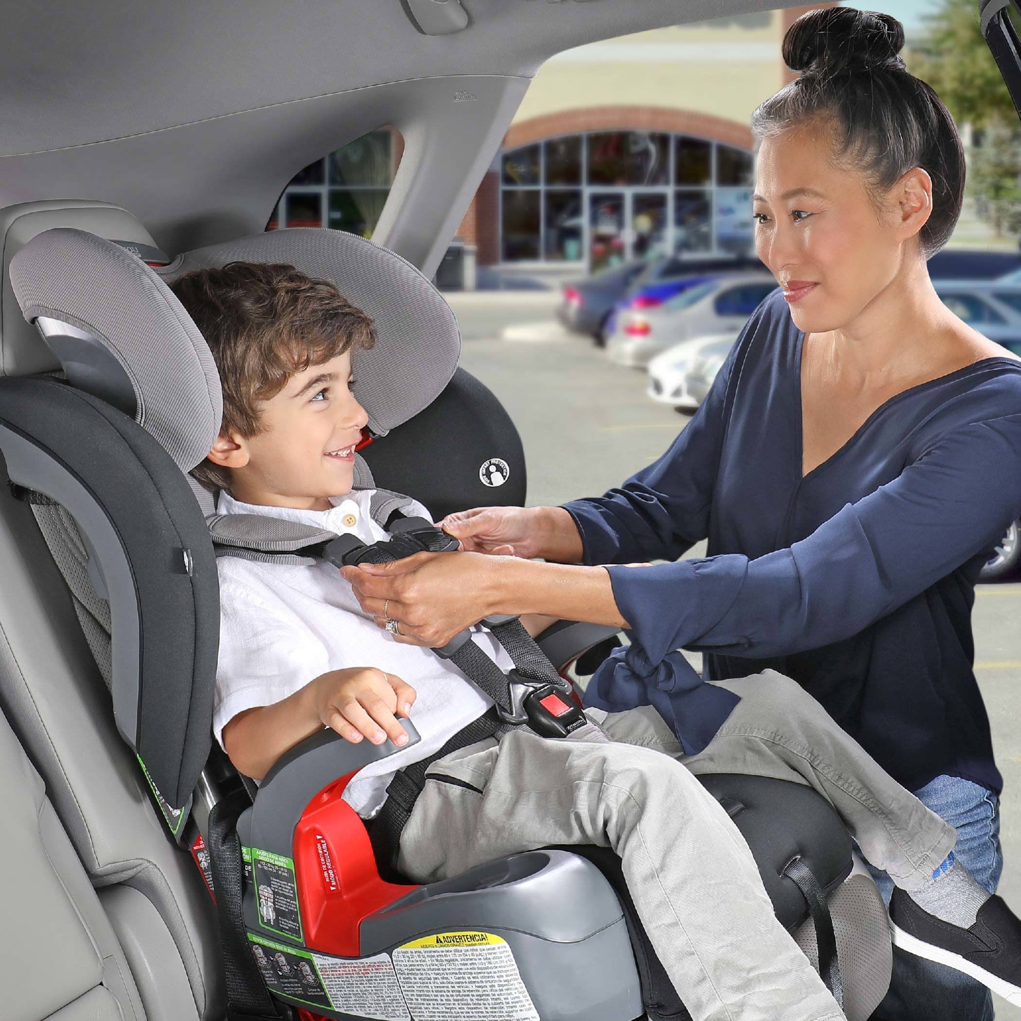 Mother adjusting the harness on a grow with you clicktight car seat