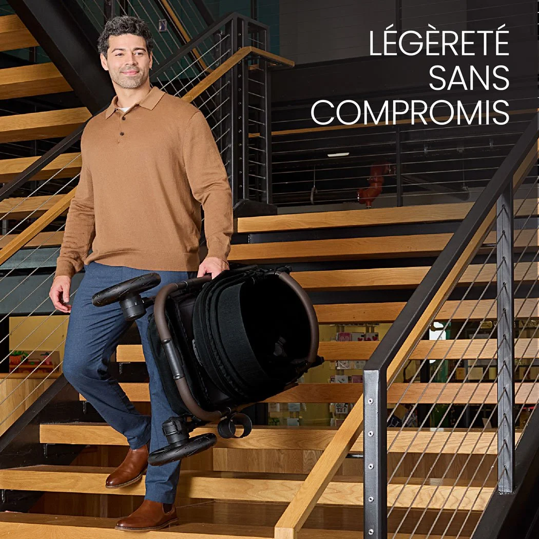 Légère sans compromis. Un homme transporte une poussette pliée dans un escalier intérieur. 