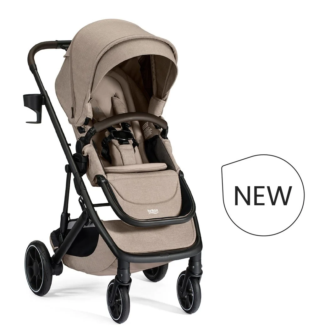 New. A tan stroller with a canopy, a brown bumper bar, a cup holder, and the Britax logo on the leg rest. 