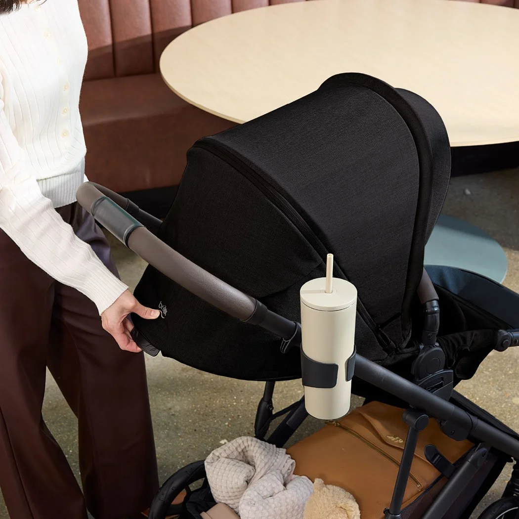 Someone adjusting the seat recline on a stroller.  