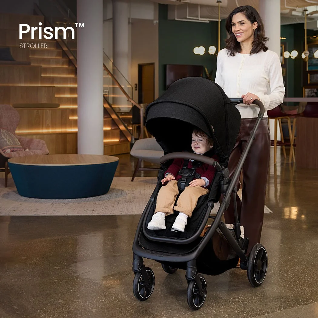 Prism stroller. A woman pushing a toddler in a stroller inside an elegant, modern building. 
