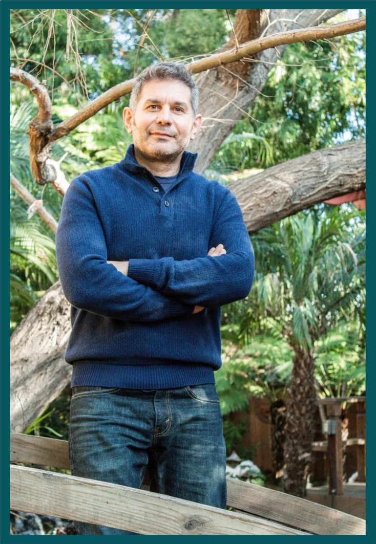 Photo of a man wearing a blue polo with his arms crossed