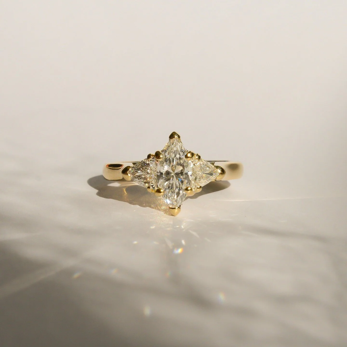 Fully handmade 18ct yellow gold engagement ring featuring marquise &amp; trilliant diamonds.