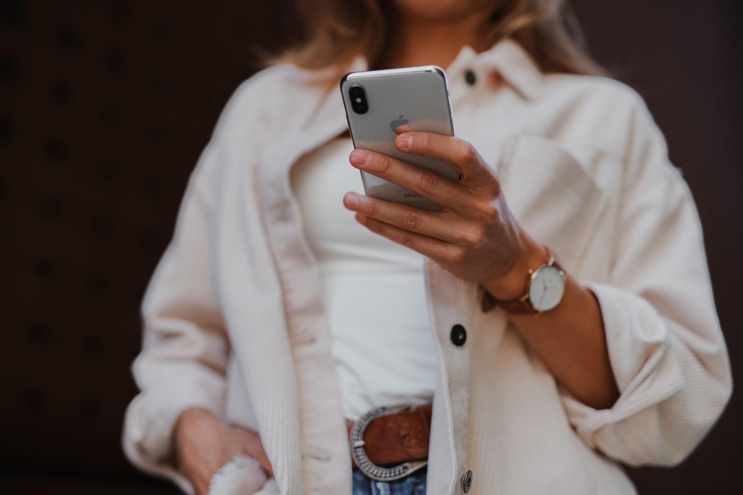 Woman in a white shirt looking at her phone at a zero waste app