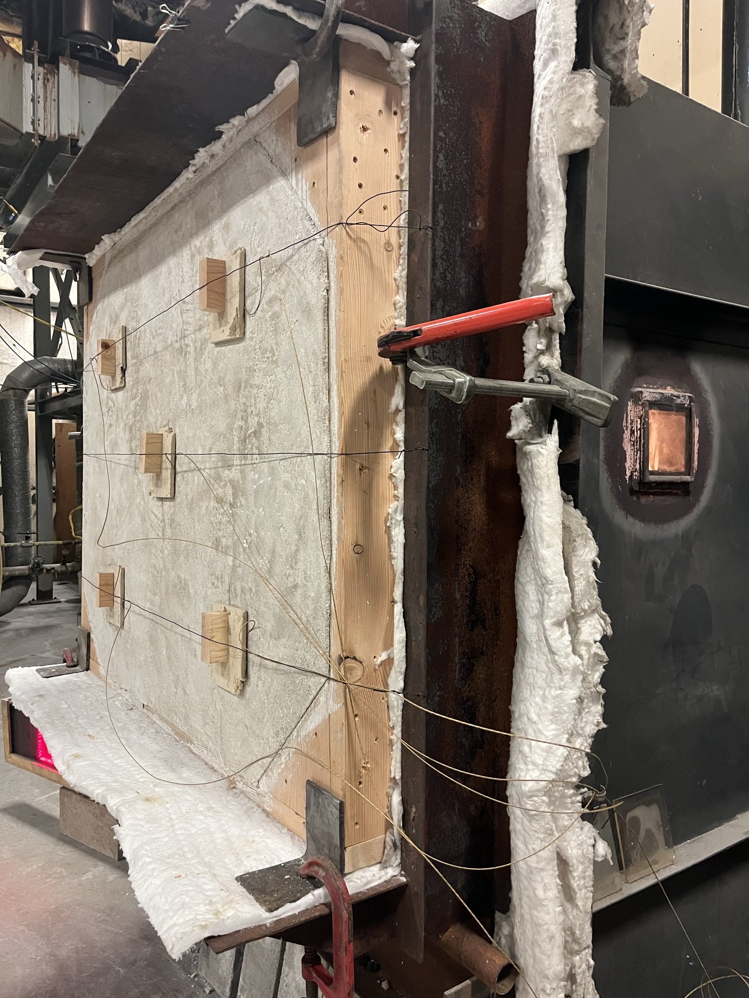 Wall secured to chamber with furnace on