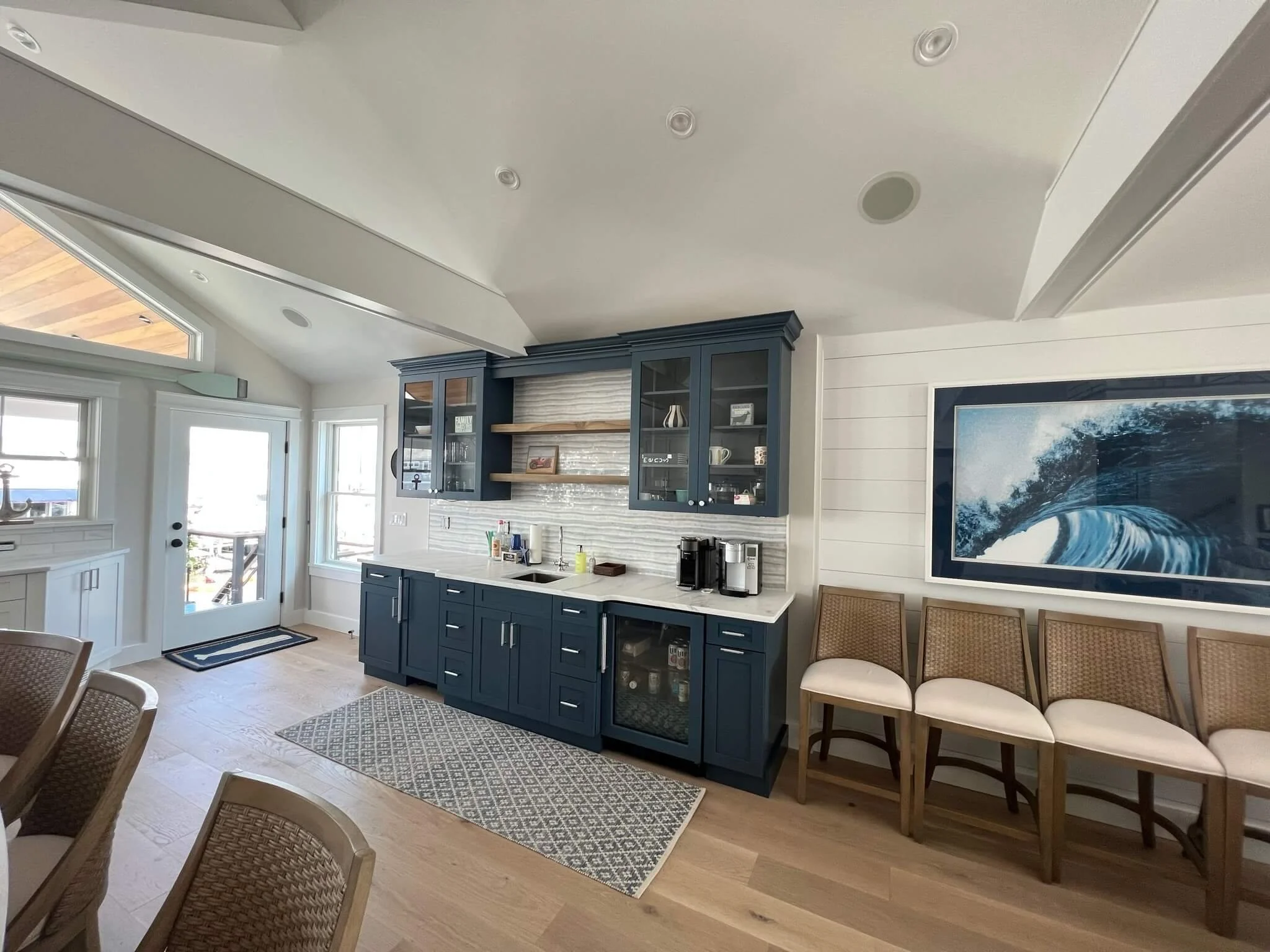 Open-concept living and kitchen area renovation with wainscoting and light oak floors by 2B Contracting