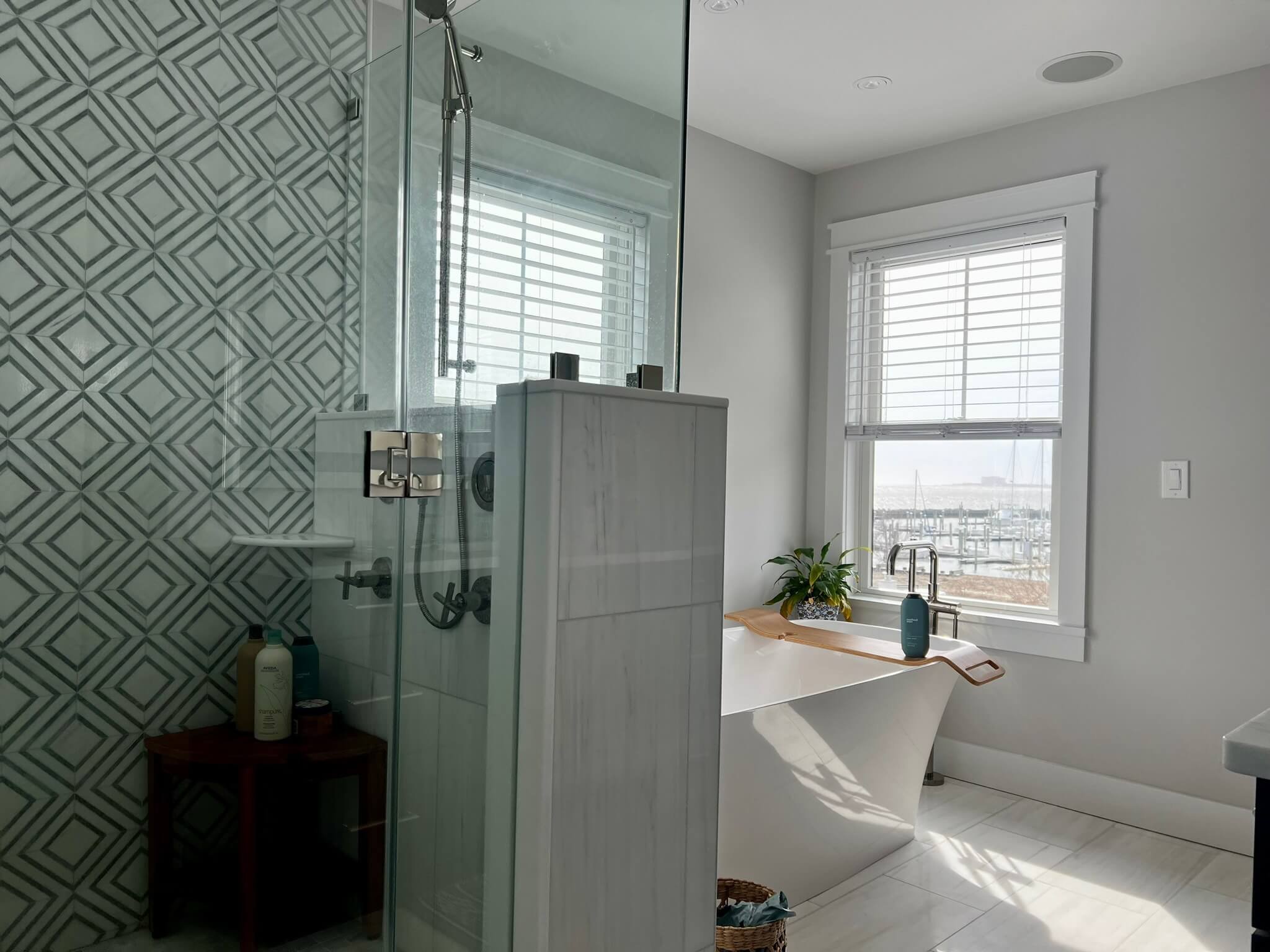 Luxury glass shower with marble hexagon accent wall, brass fixtures, and tiled niche installed by 2B Contracting in Ocean City, NJ.