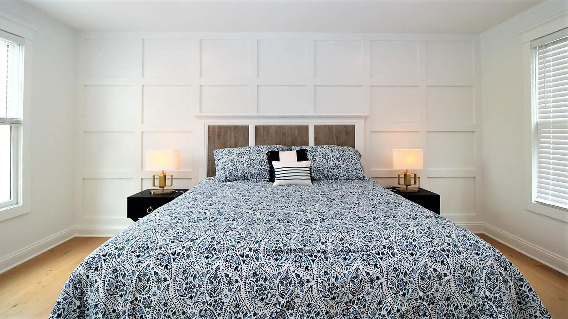 Ocean City primary bedroom with custom trim accent wall and natural oak flooring by 2B Contracting.