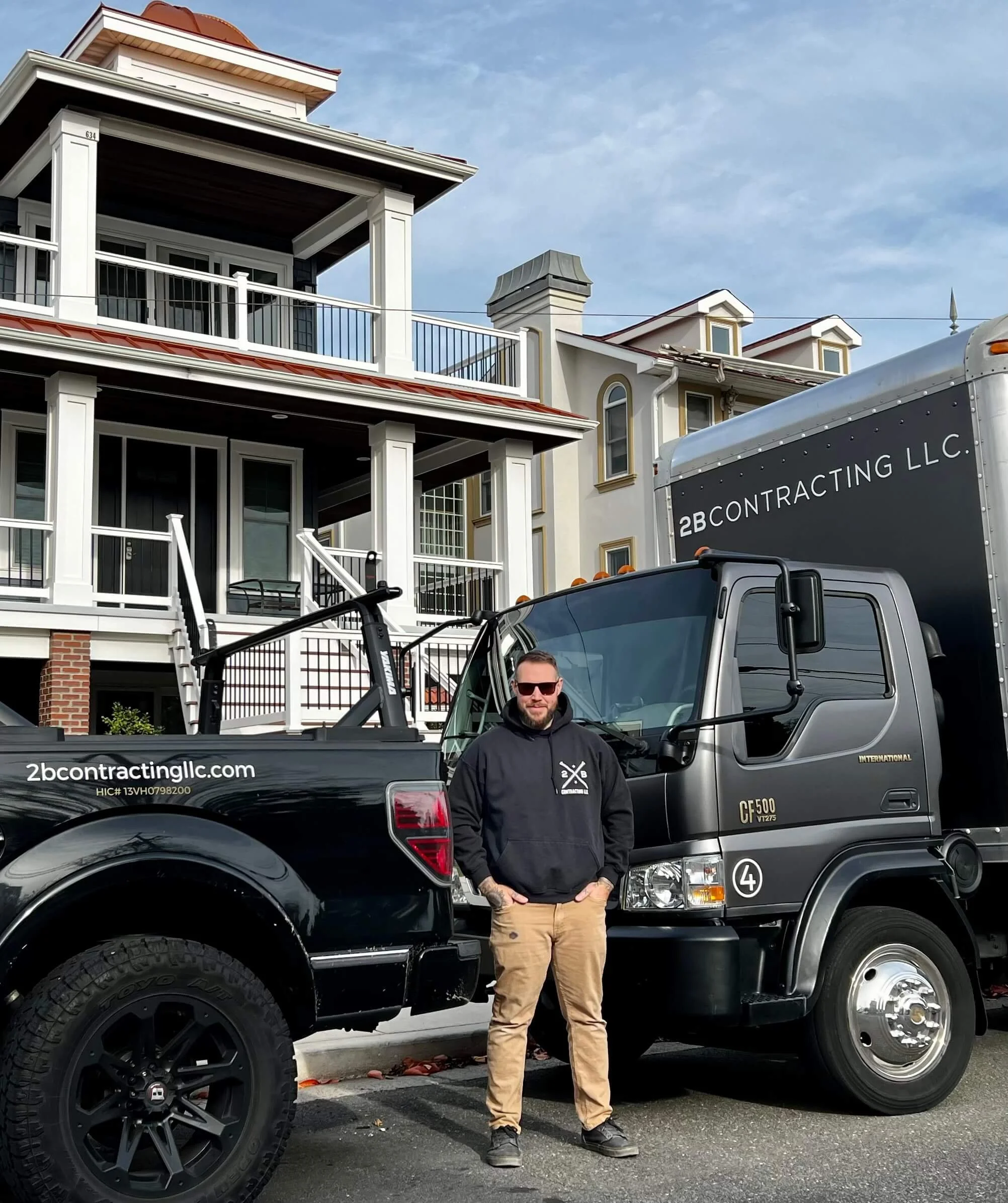 2B Contracting LLC owner standing in front of branded work truck and luxury coastal home in Ocean City, NJ