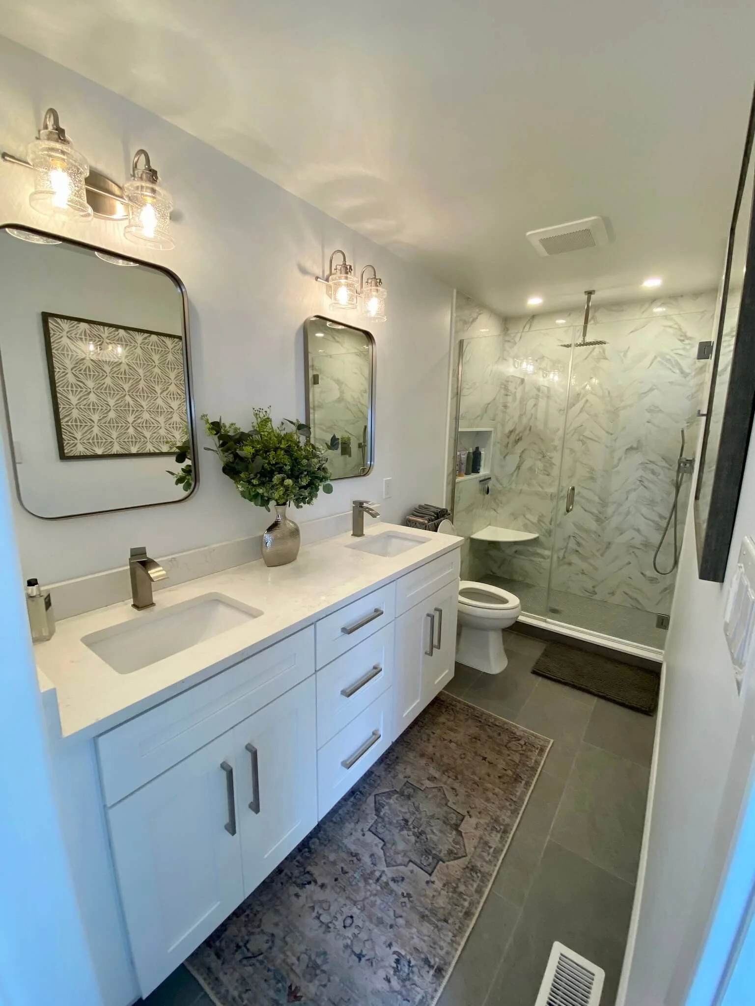 Ocean City bathroom remodel featuring white double vanity, quartz top, and frameless glass shower with marble tile
