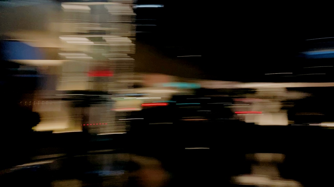 Abstract blurred image of city lights at night, suggesting a fast-moving and fragmented screen media landscape.