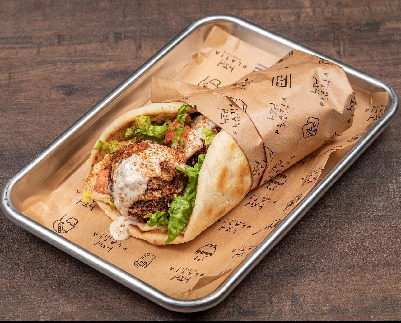 🌯 Craving a delicious Mediterranean delight? Look no further than Platia Greek Goodness! 🇬🇷 Indulge in our mouthwatering Falafel Wrap&mdash;grilled pita bread filled with flavorful falafel, creamy hummus, fresh lettuces, juicy tomatoes, and drizzl
