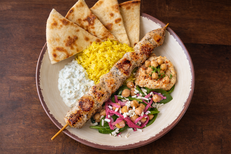 Build Your Bowl at Platia Greek Goodness — Mediterranean bowl with grilled protein, salad, spreads, and pita