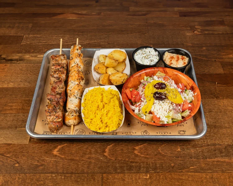 Build Your Platter at Platia Greek Goodness — Mediterranean platter with grilled protein, rice, salad, spreads, and pita