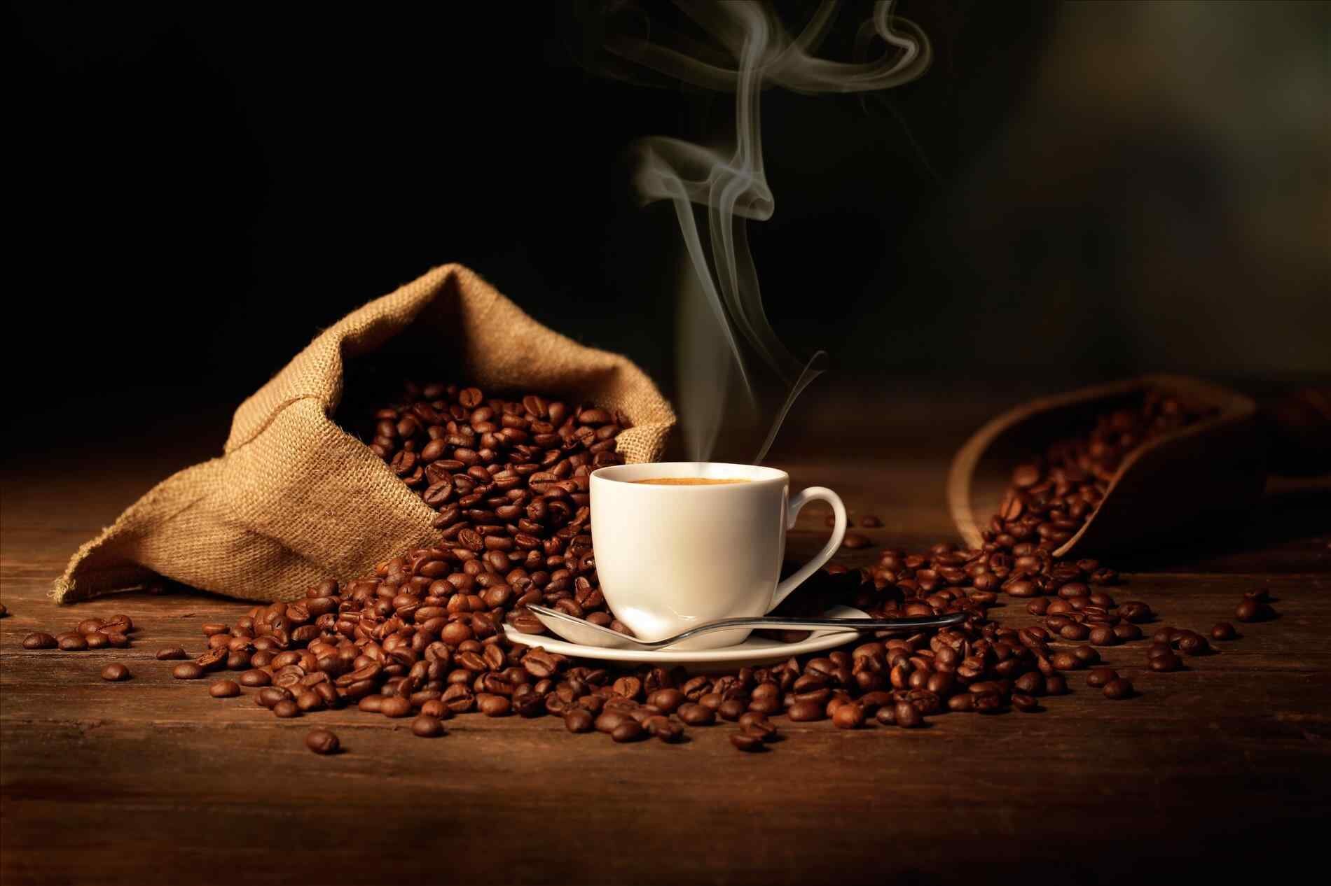 background-young-man-puts-a-of-black-with-roasting-young-coffee-beans-and-cup-background-man-puts-a-of-black-with-roasting-on.jpg